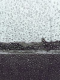 Full frame shot of raindrops on glass window