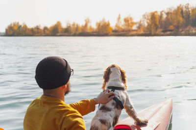 Man with dog in boat on lake