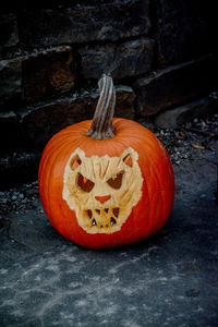 Close-up of pumpkin on stone wall during halloween