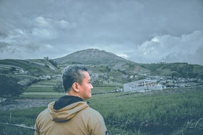 Man standing on field against mountains