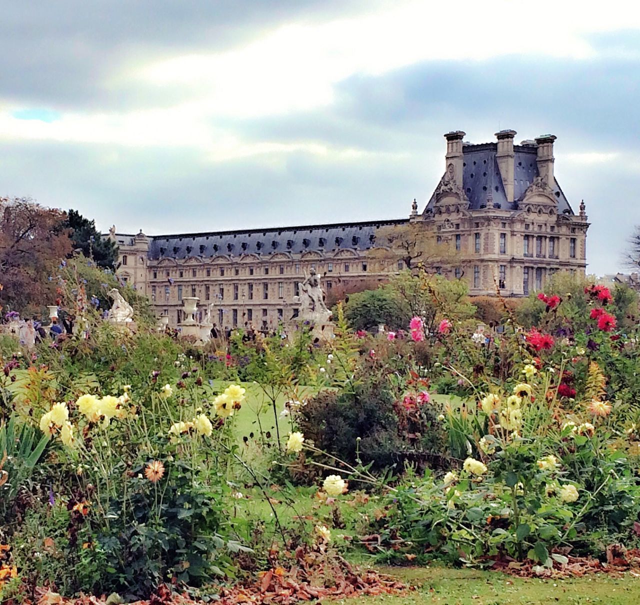 architecture, built structure, building exterior, flower, sky, cloud - sky, plant, history, growth, famous place, cloud, freshness, travel destinations, low angle view, day, tree, cloudy, grass, travel, outdoors