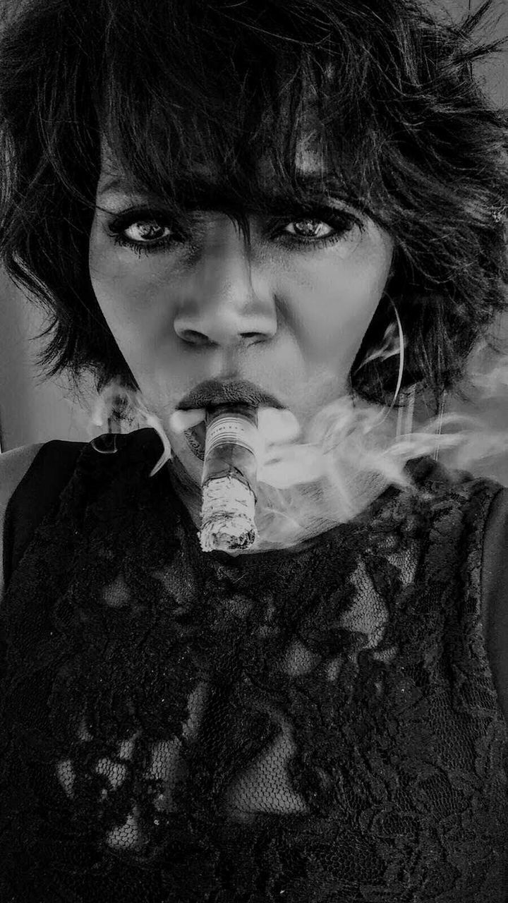 portrait, one person, looking at camera, headshot, front view, lifestyles, real people, young adult, close-up, cigarette, leisure activity, smoke - physical structure, bad habit, smoking - activity, smoking issues, hairstyle, social issues, activity, beautiful woman