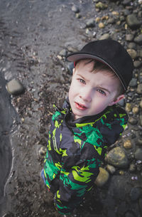 High angle portrait of boy standing at beach