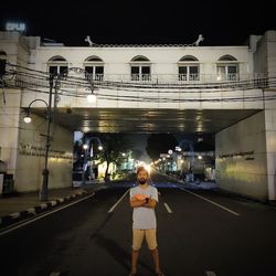 Woman standing on illuminated street at night