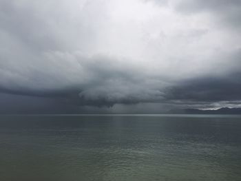 Scenic view of sea against storm clouds