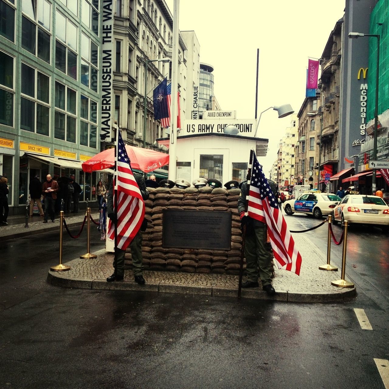 building exterior, architecture, built structure, city, street, flag, patriotism, city life, national flag, american flag, building, identity, day, red, men, road, residential structure, outdoors, incidental people