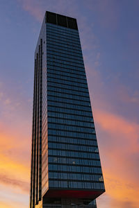 Low angle view of modern building against sky at sunset