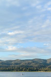 Scenic view of river against cloudy sky