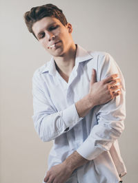 Young man standing against white background