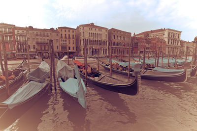 Boats moored on shore against sky