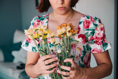 Midsection of woman holding flowers