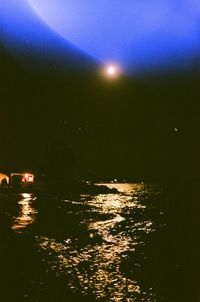 Aerial view of illuminated sea against sky at night