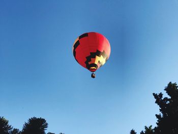 Low angle view of hot air balloon against clear blue sky