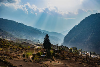 Misty mountain valley with sun rays beams at morning from flat angle