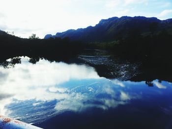 Scenic view of lake and mountains against sky
