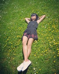 High angle view of woman lying on grassy field