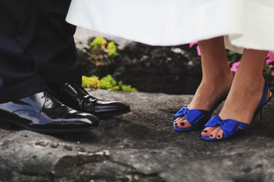 Low section of bride and groom outdoors