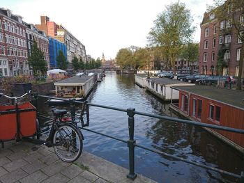 Canal amidst city against sky