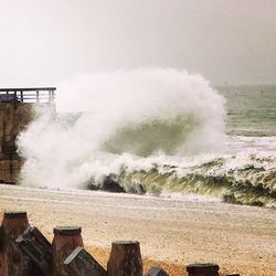 Waves splashing on sea against sky