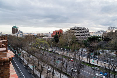 High angle view of cars on road by buildings in city against sky