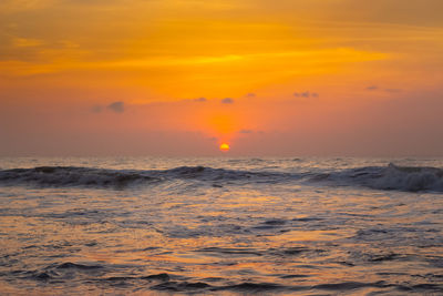 Scenic view of sea against orange sky