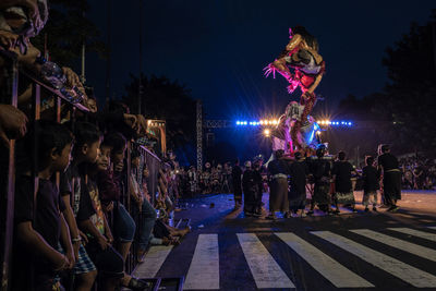 Crowd on illuminated street at night