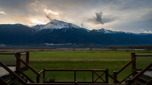 Scenic view of field and mountains against sky