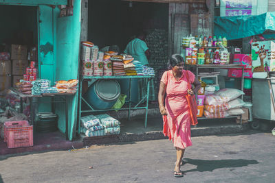 Rear view of woman standing at market stall