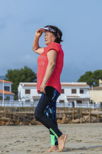 Side view of man holding umbrella against sky