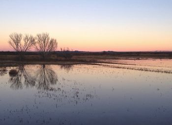 Scenic view of calm lake at sunset