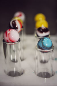 Close-up of marbles in glasses on table