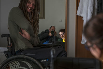 Three friends took a photo in a mirror in a hotel room