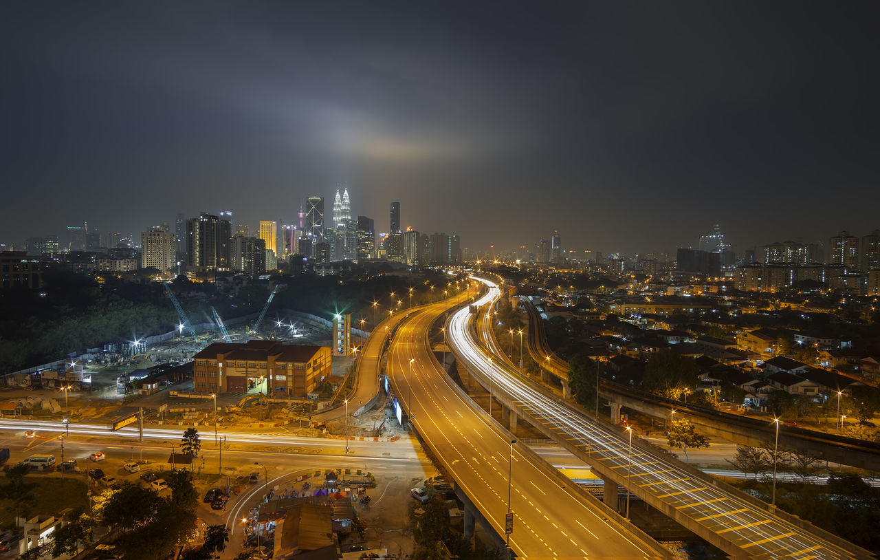 illuminated, city, night, building exterior, architecture, built structure, high angle view, cityscape, road, transportation, city life, street, sky, street light, skyscraper, city street, light trail, car, traffic, outdoors