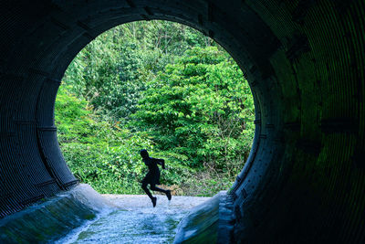 Silhouette girl jumping in tunnel