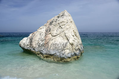 Scenic view of rocks in sea against sky