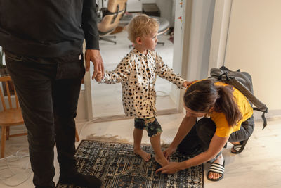 Mother helping son put his shoes on