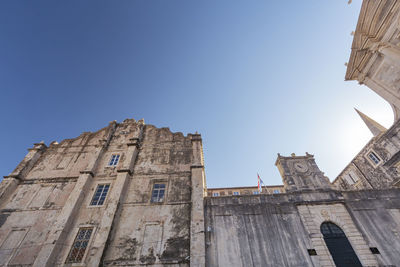 Low angle view of old building against clear blue sky