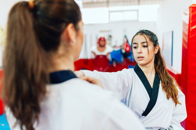 Young woman with instructor practicing martial arts