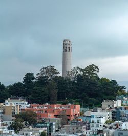 Buildings in city against cloudy sky