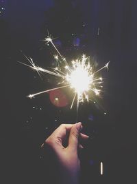 Cropped image of person holding sparkler