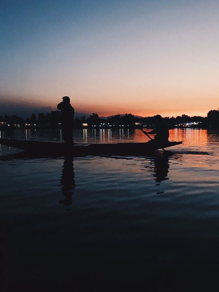 SILHOUETTE MAN STANDING ON LAKE AGAINST SKY DURING SUNSET