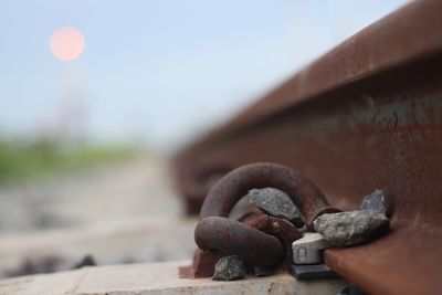 Close-up of rusty machine part against sky