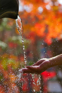 Close-up of hand under water falling from fountain