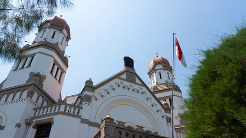 Low angle view of flags on building against sky