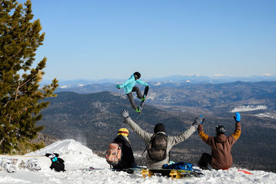 Group of people on mountain range against sky