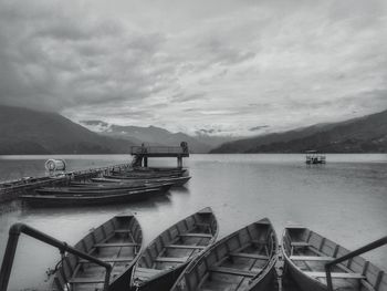 Boats moored on lake against sky