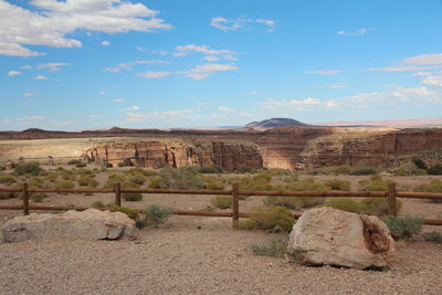 Stone wall on arid landscape against sky