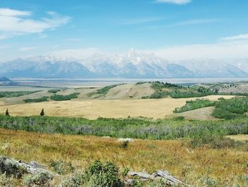 Scenic view of field and mountains against sky