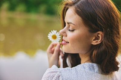 Close-up of young woman holding flower