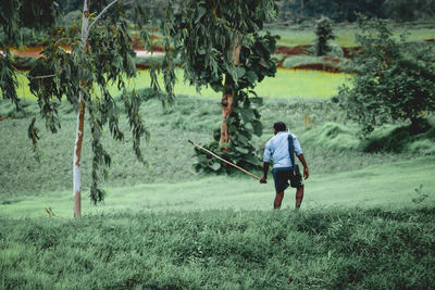 Rear view of man walking on field